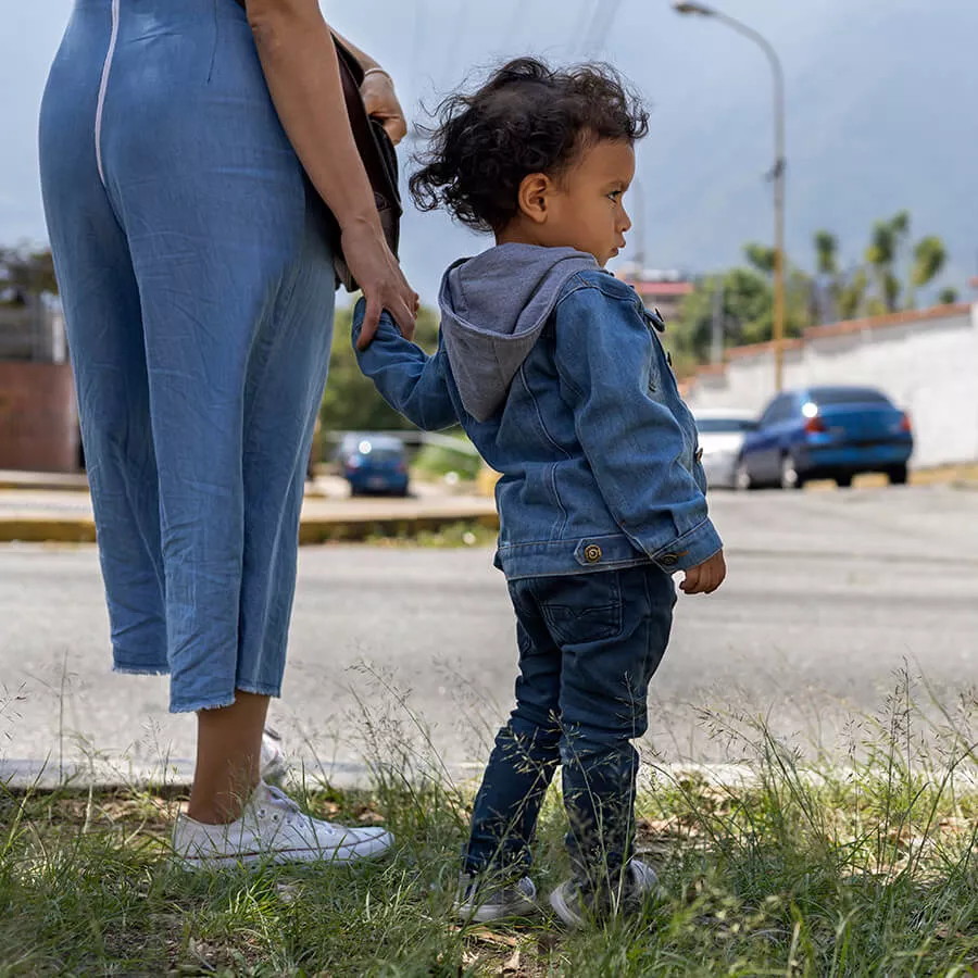 parent holds young child's hand