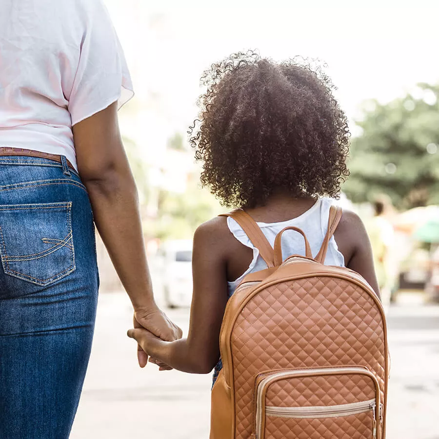 Parent holding child's hand at side of road