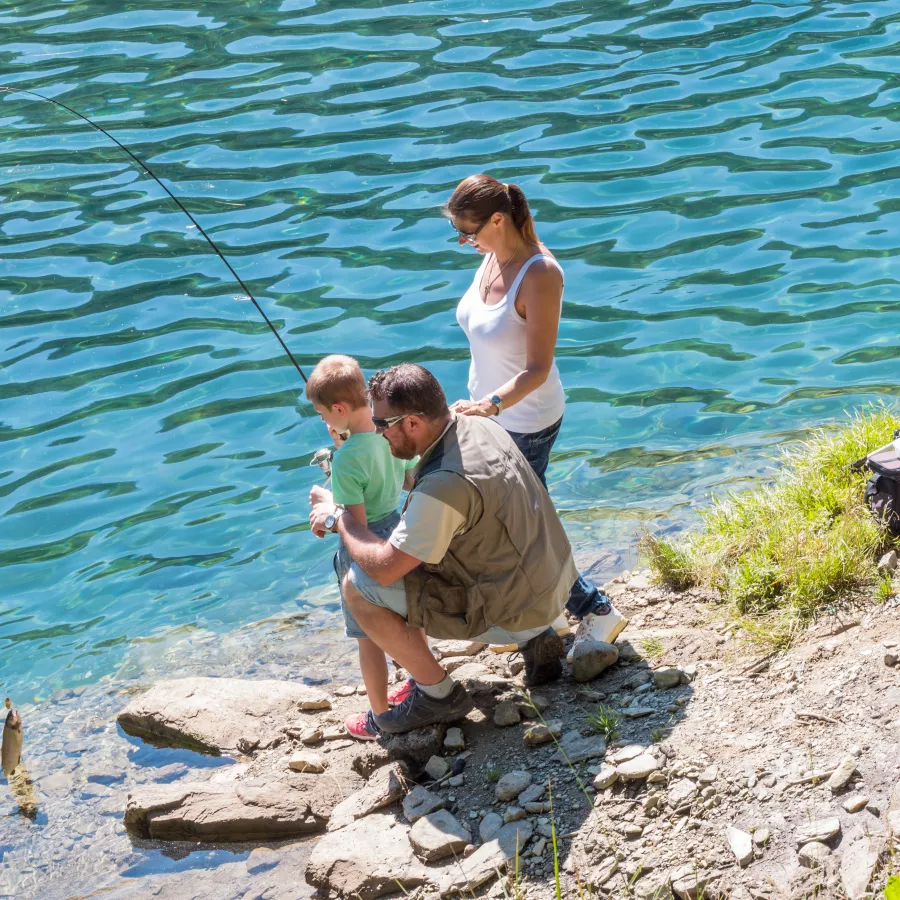 Parents supervising child at edge of water