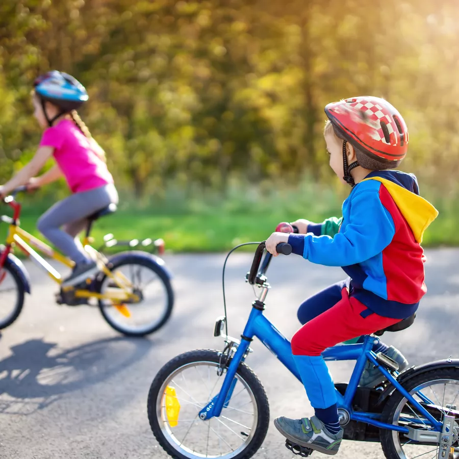 two children ride bikes in the street
