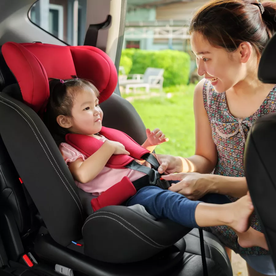 Mother checks a child's seatbelt