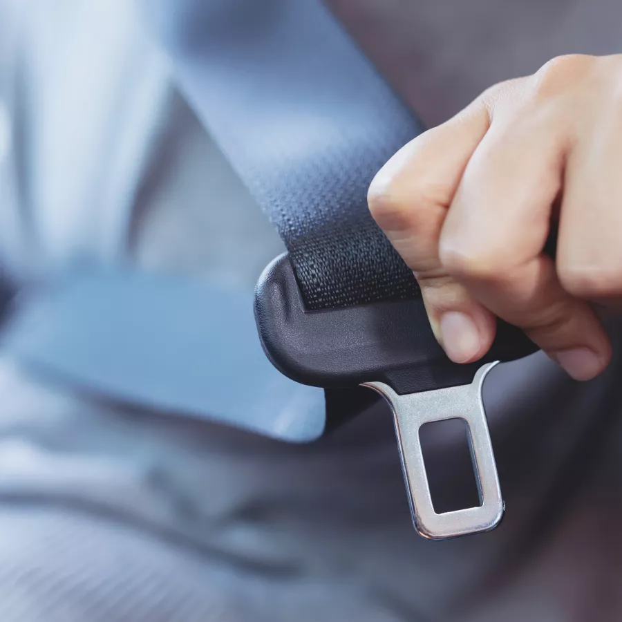 passenger holds a seat belt buckle