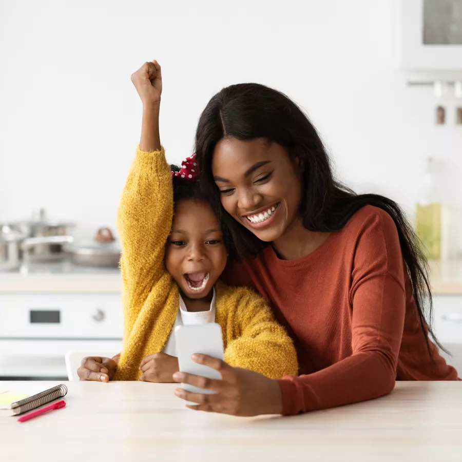 Mother and daughter look at cell phone