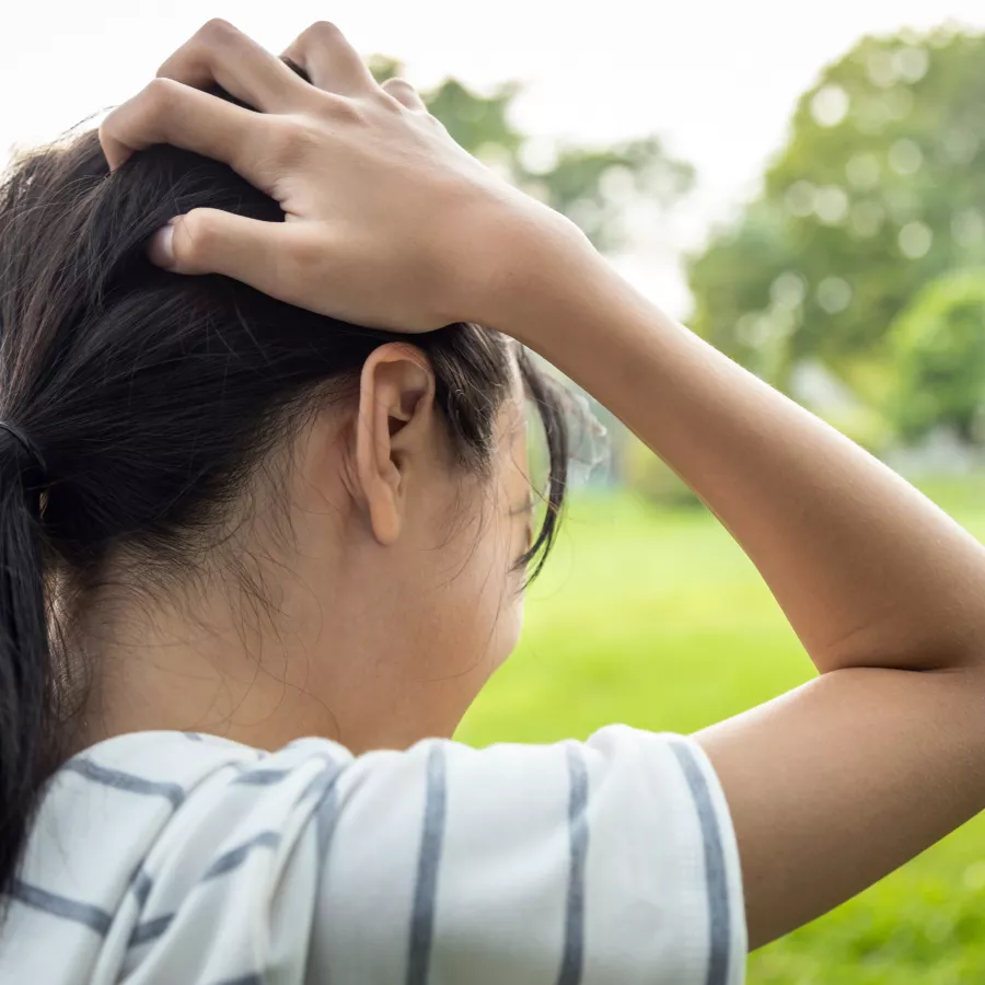 girl holding her head in pain